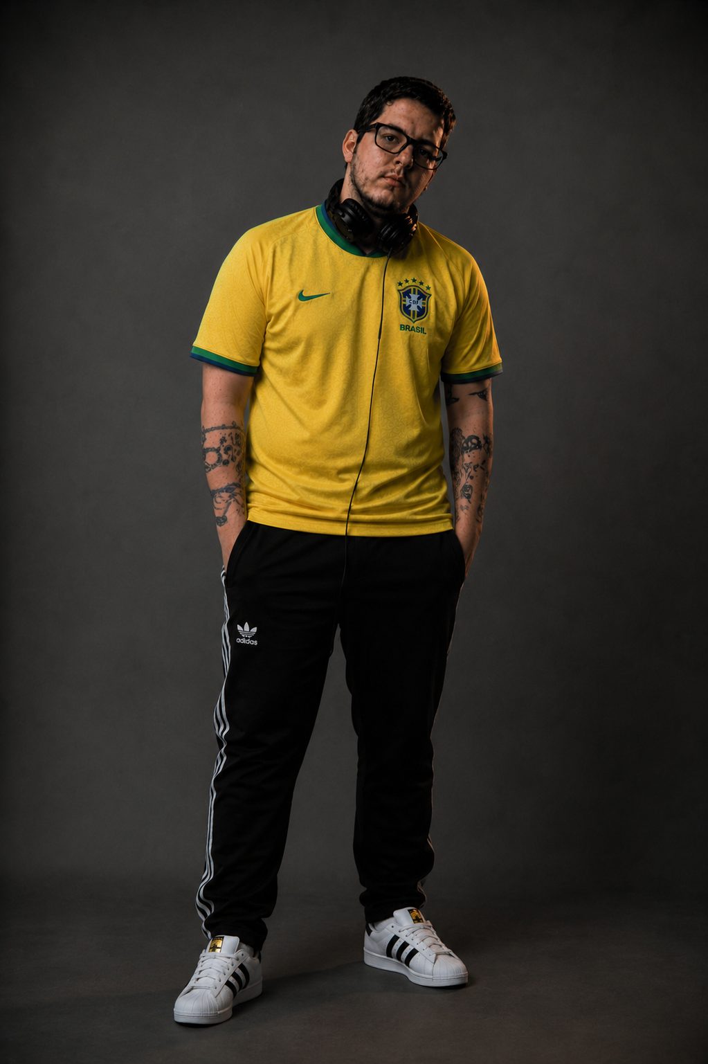 DJ Lipe de corpo inteiro, camisa amarela e tênis branco