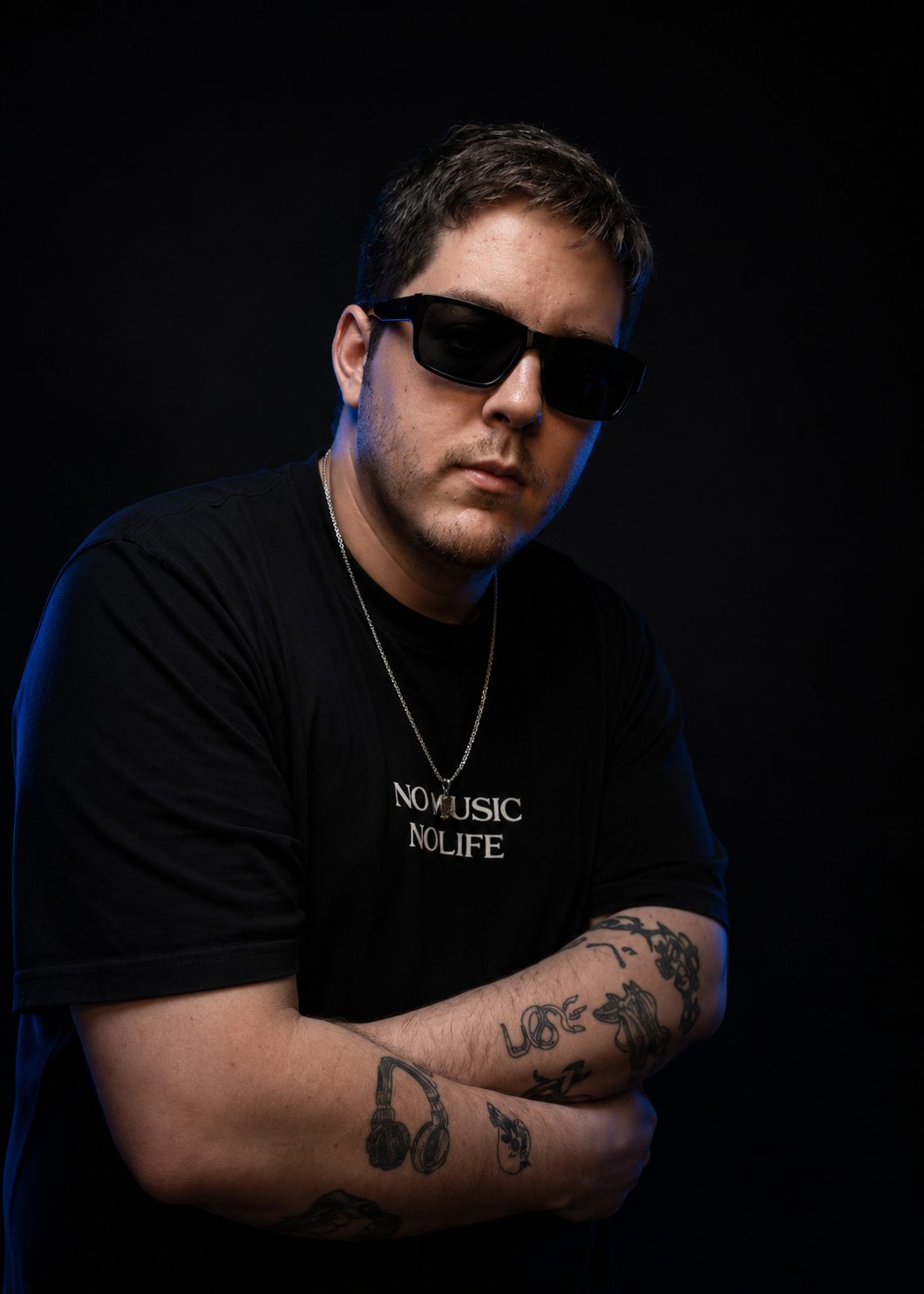 DJ Lipe de braços cruzados e óculos escuros
