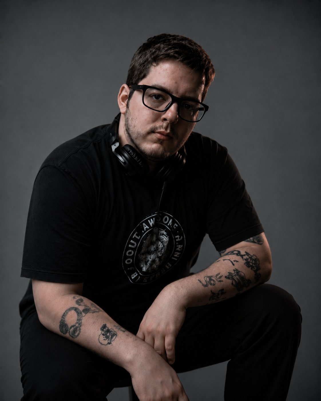 DJ Lipe sentado, de camiseta preta e fone no pescoço