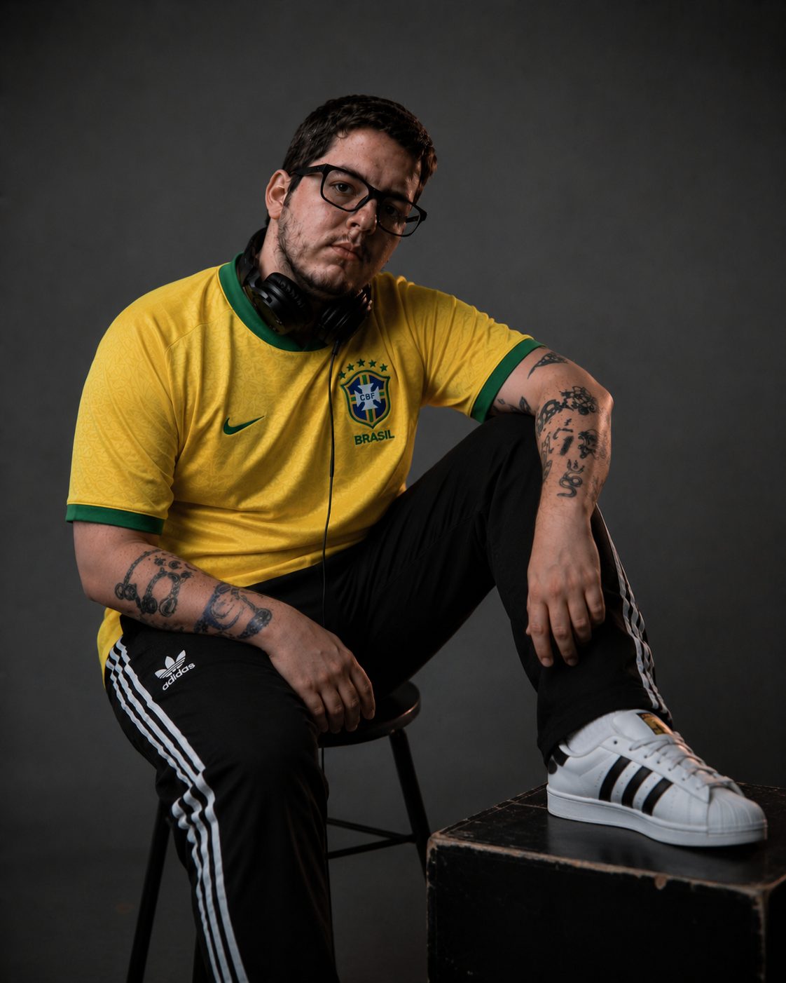 DJ Lipe sentado no banco, camisa amarela
