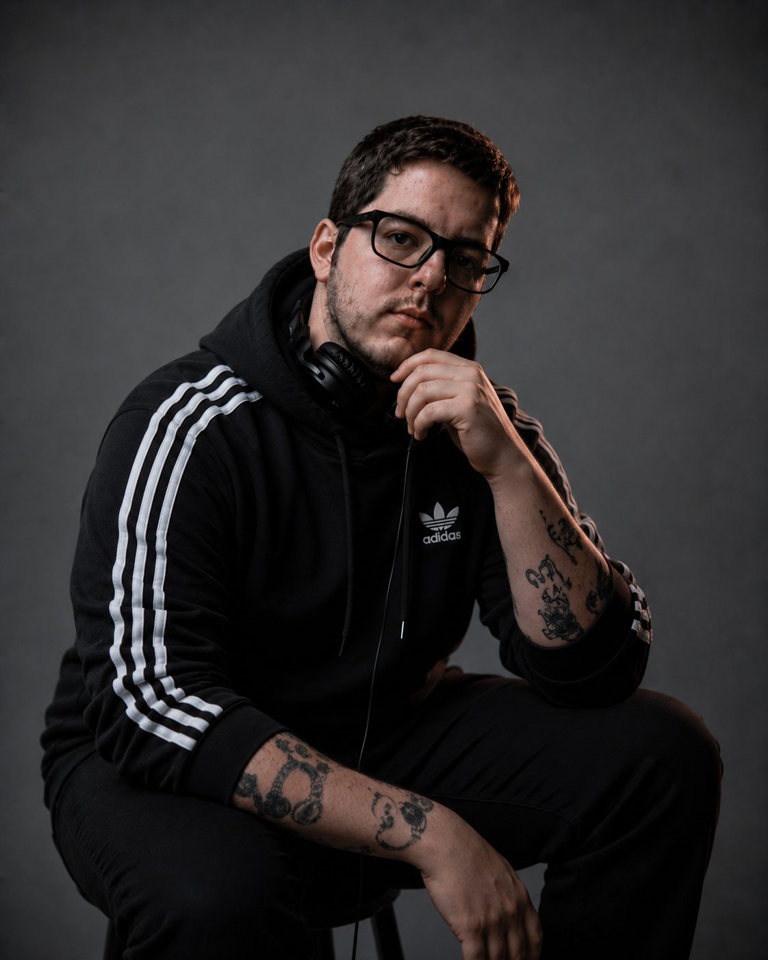 DJ Lipe de jaqueta preta listrada, mão no queixo